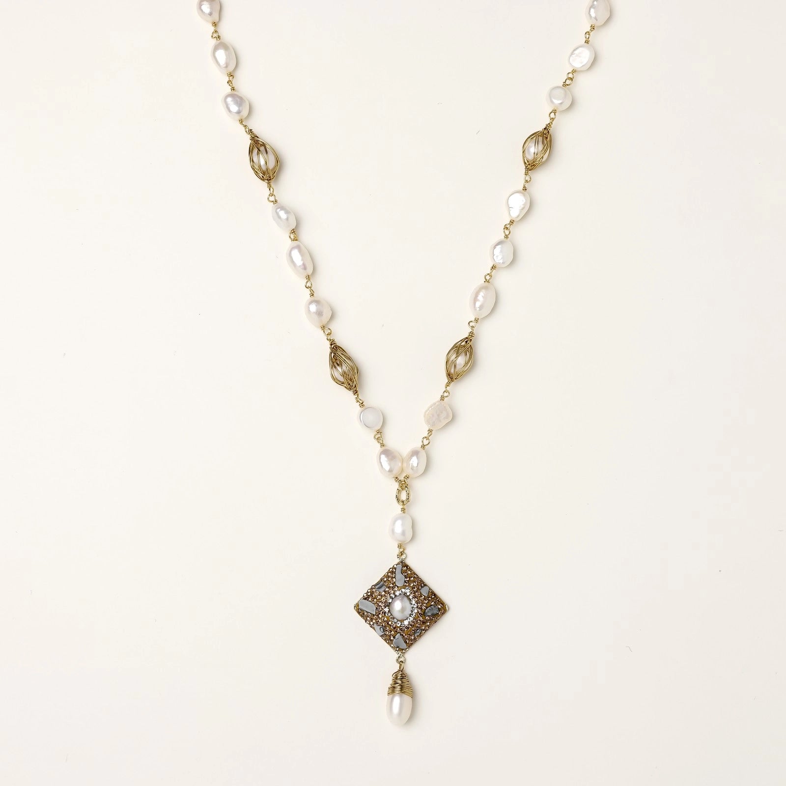 Elegant 14K gold plated necklace with freshwater pearls and ornate crystal diamond pendant on cream background.