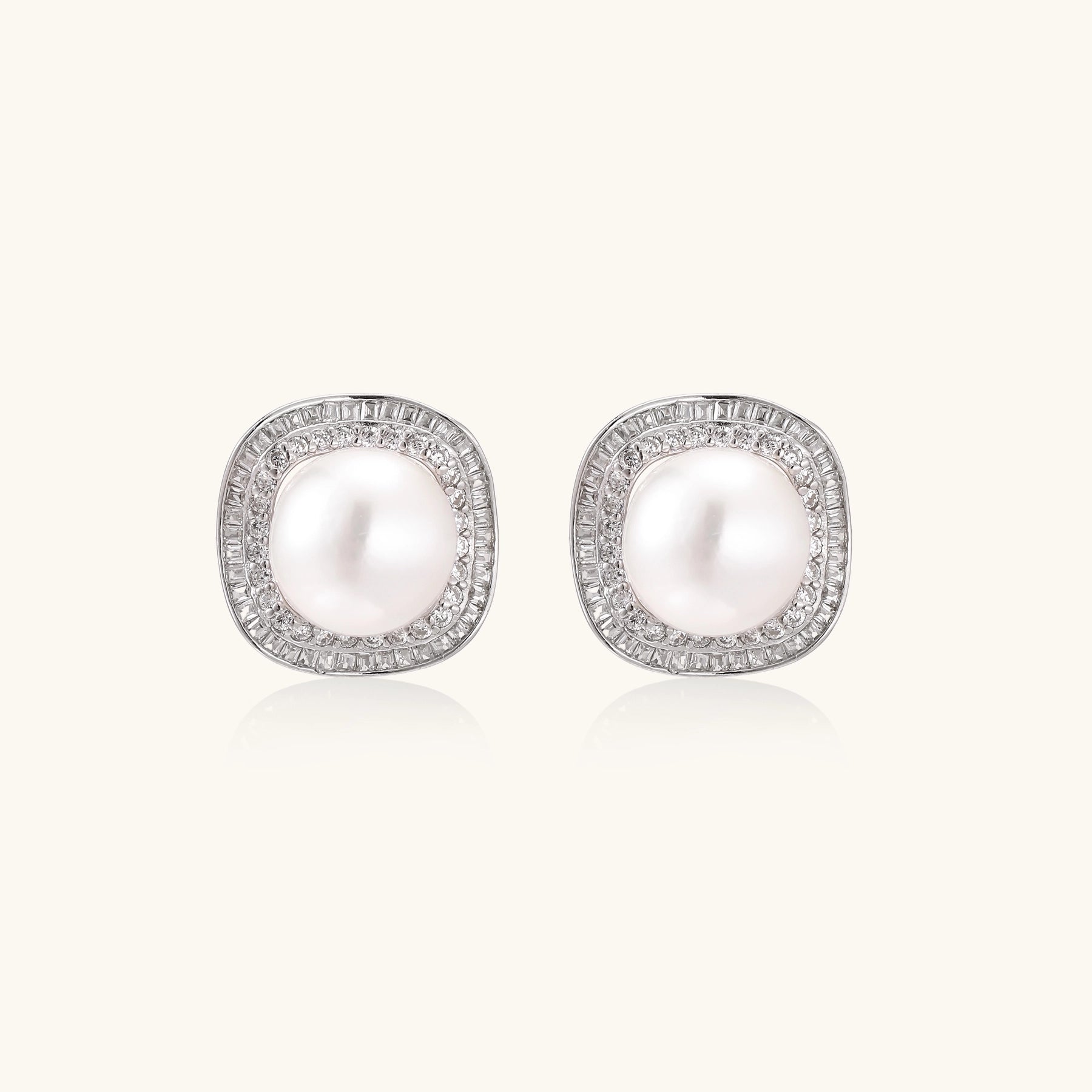 Sterling silver stud earrings with round freshwater pearls surrounded by sparkling crystal halos on white background.