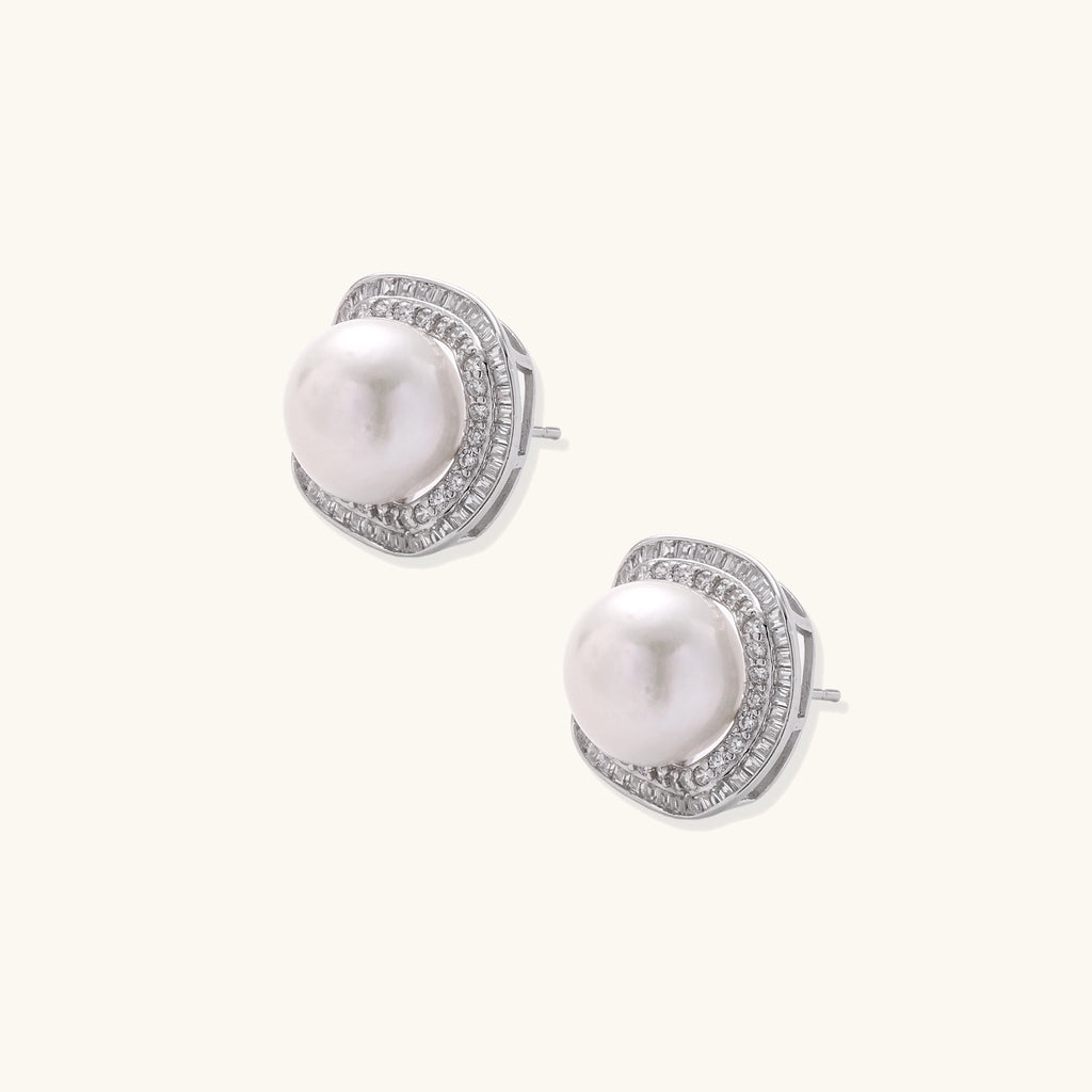 Sterling silver stud earrings with round freshwater pearls surrounded by sparkling crystal halos on white background.