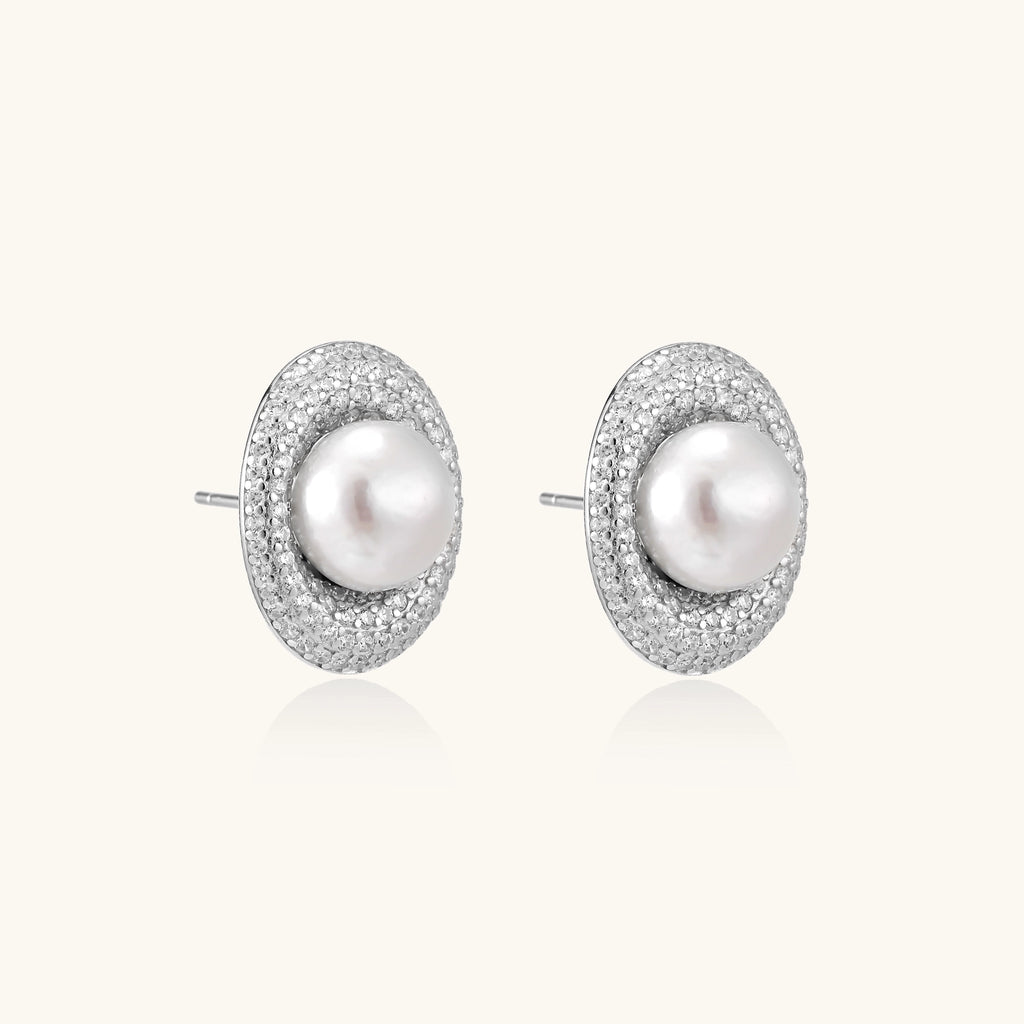Sterling silver stud earrings with freshwater pearls surrounded by sparkling pavé crystals on white background.