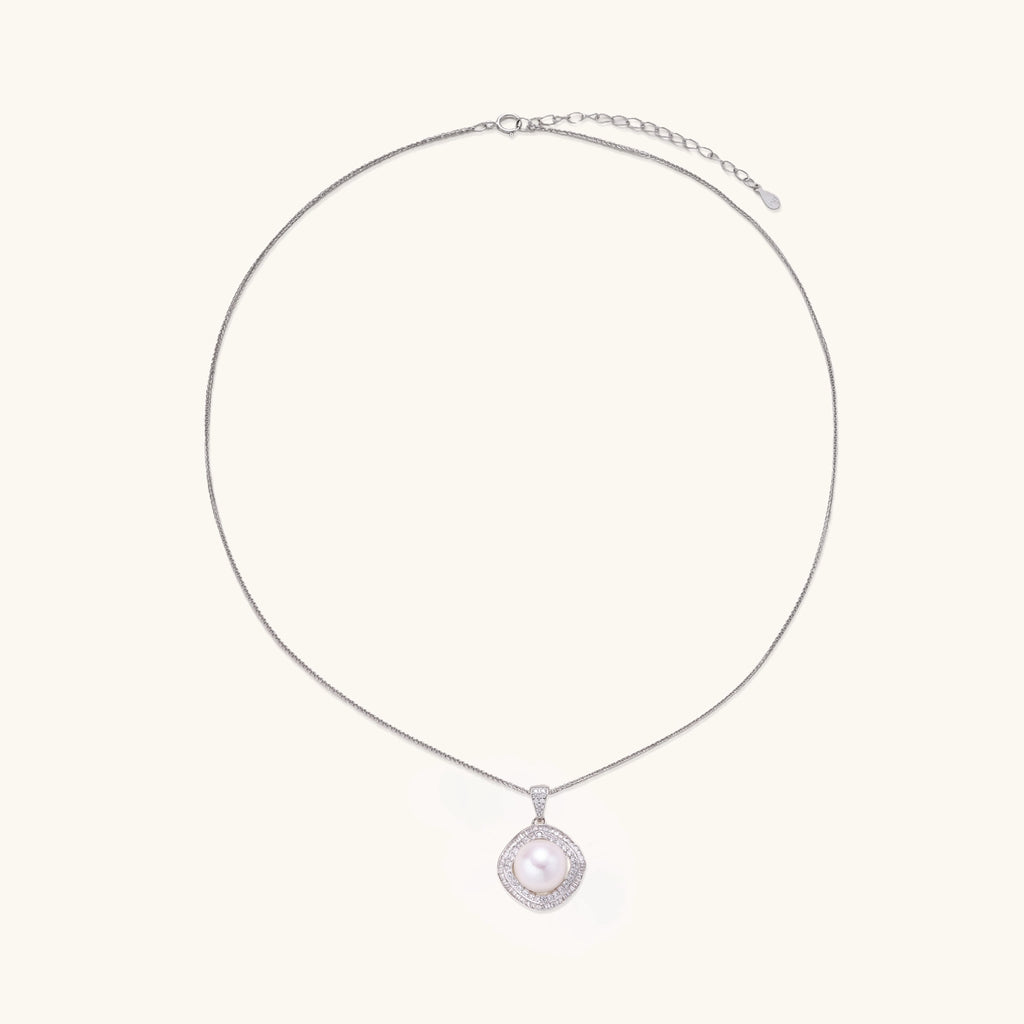 Sterling silver necklace with geometric halo setting surrounding a 10mm freshwater pearl on white background.