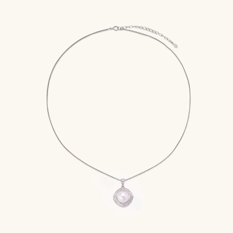 Sterling silver necklace with geometric halo setting surrounding a 10mm freshwater pearl on white background.