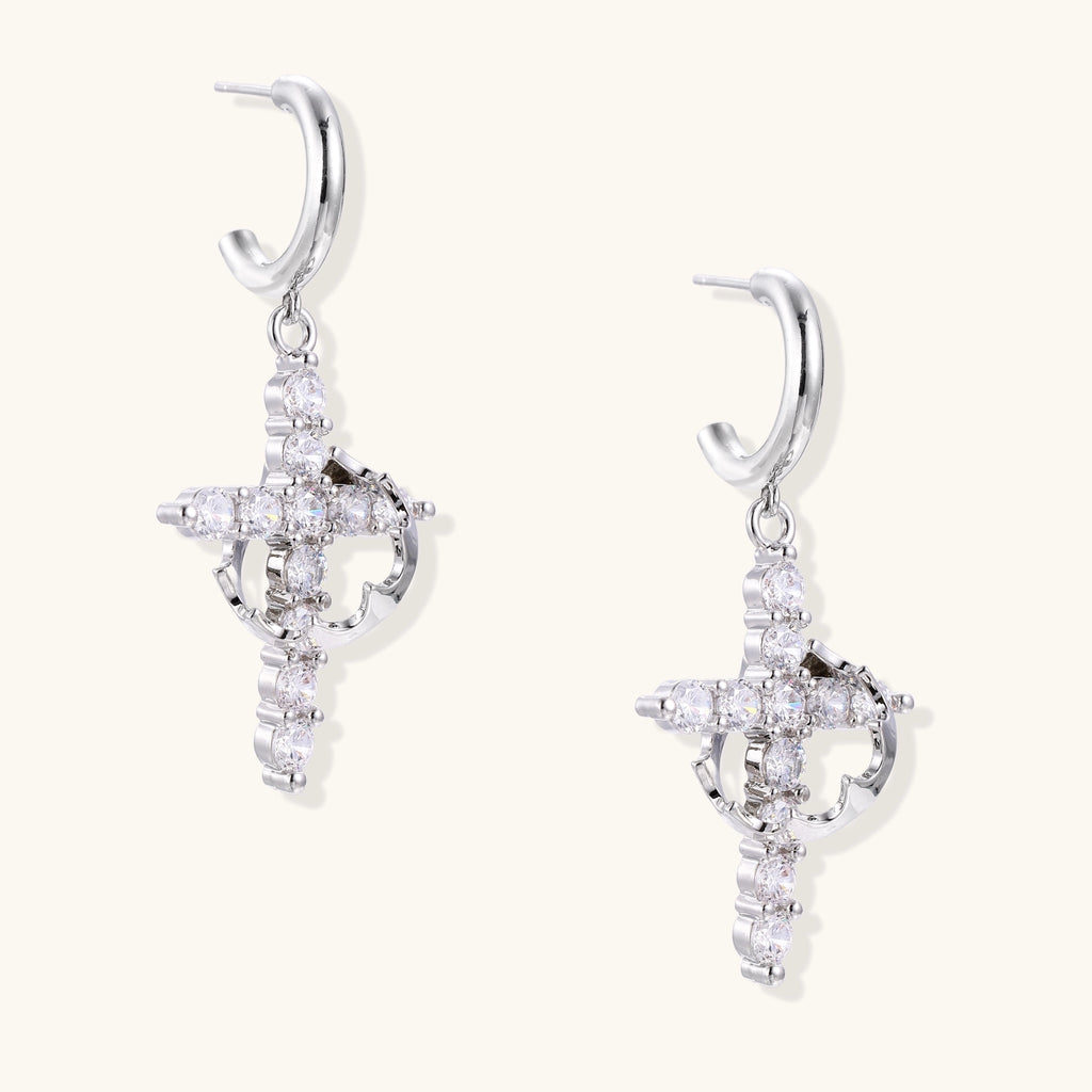Ornate cross dangle earrings with zirconia stones and gold-plated brass construction on white background.