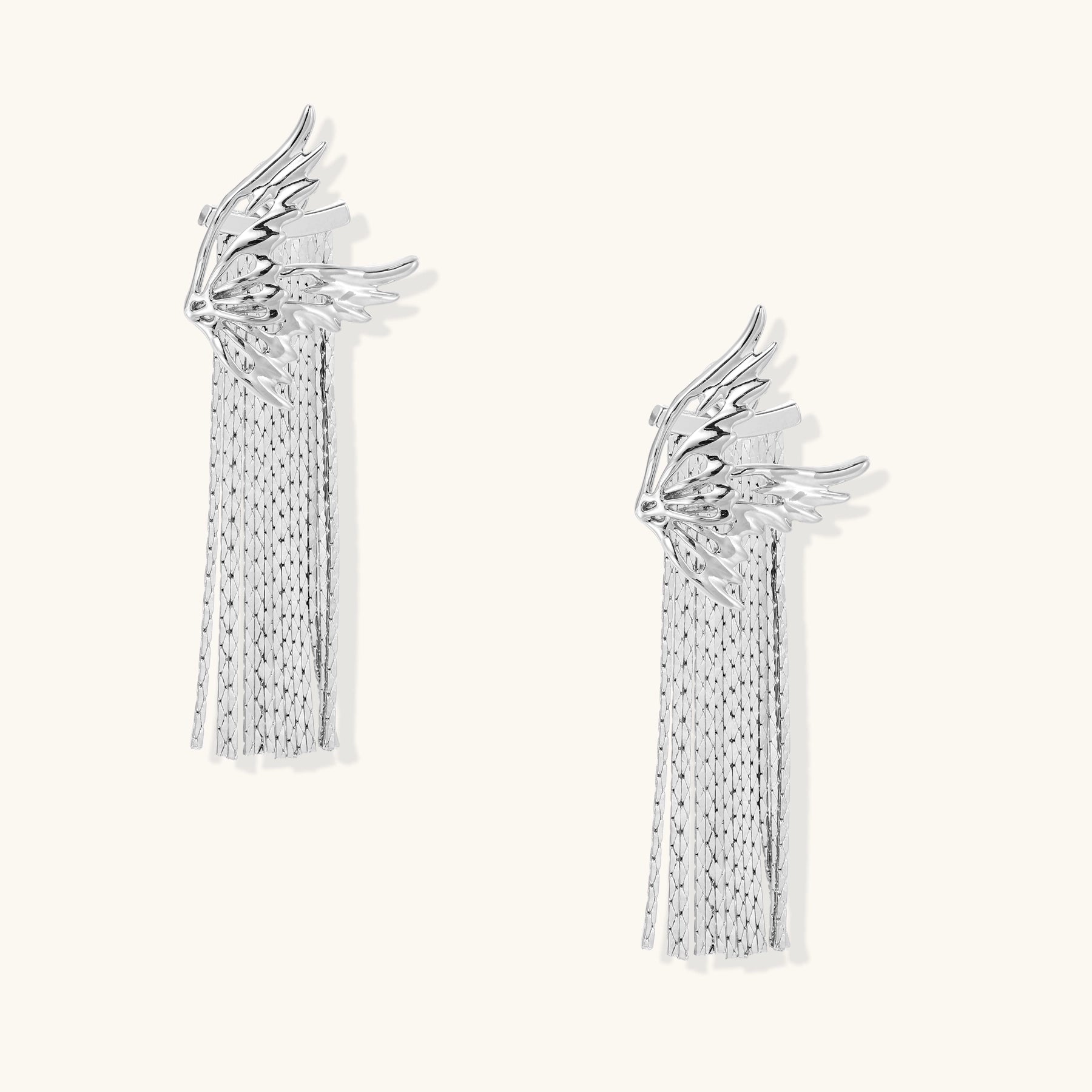 Gold-plated wing earrings with delicate chain fringe tassels creating movement and celestial appeal
