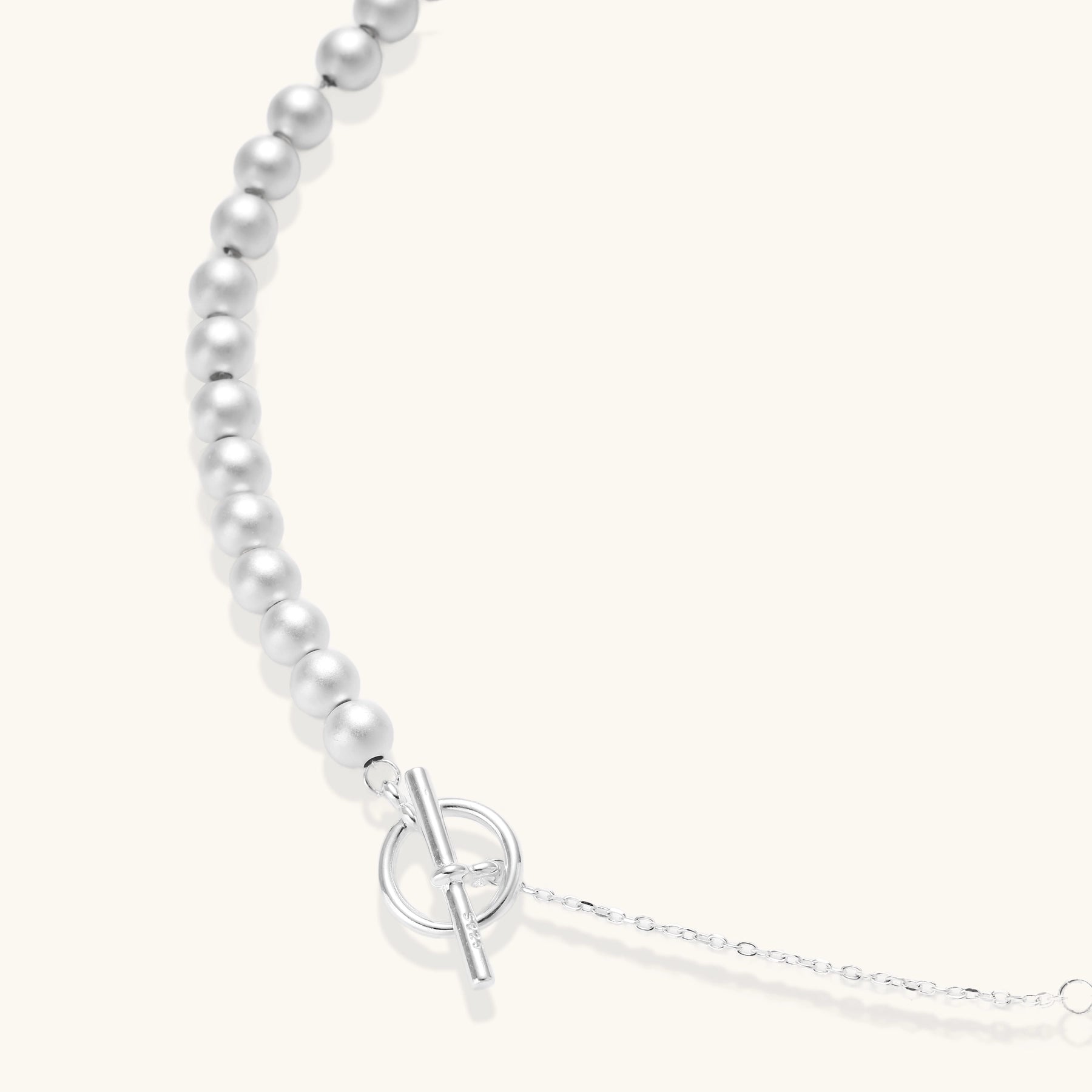 Sterling silver necklace with graduated pearl beads and delicate chain sections featuring a toggle clasp closure.