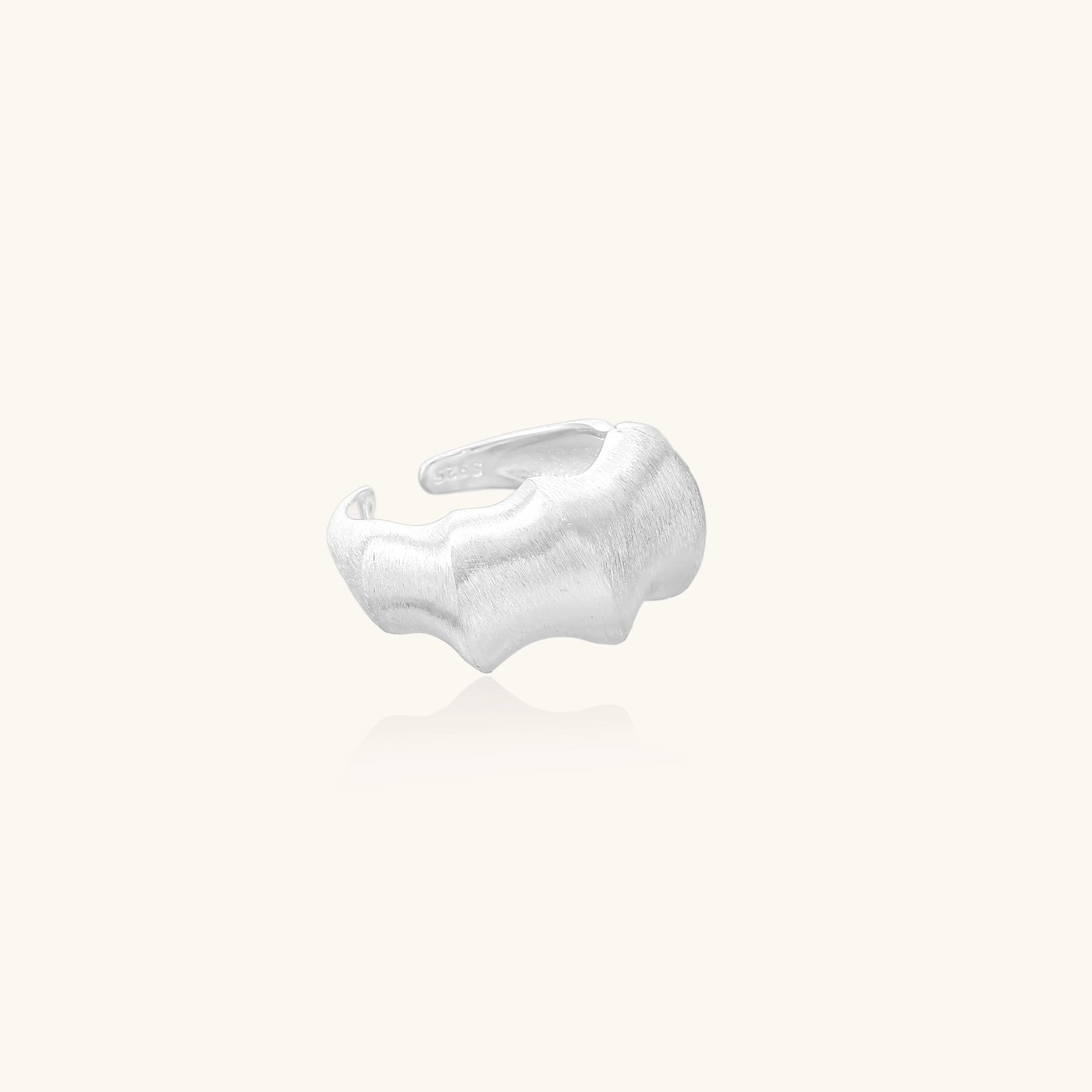 Chunky sterling silver ring with organic flowing design and brushed matte finish on neutral background