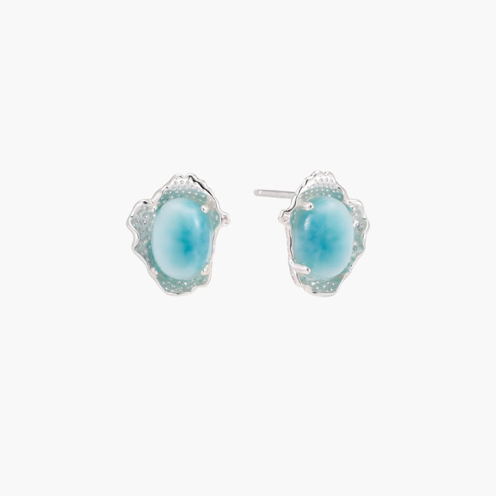Oval larimar gemstone studs with ornate silver settings showing natural turquoise marbling on cream background