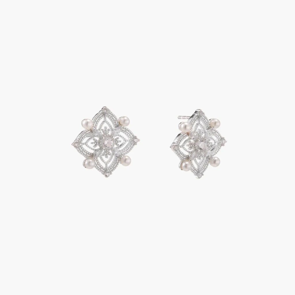 Ornate sterling silver stud earrings with mandala-inspired filigree pattern and four freshwater pearls on beige background