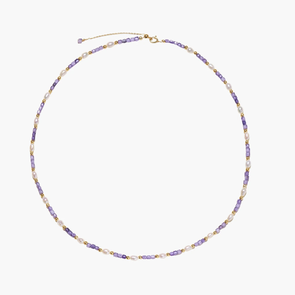 Delicate 18K gold vermeil necklace with alternating lavender zirconia beads and white freshwater pearls on cream background