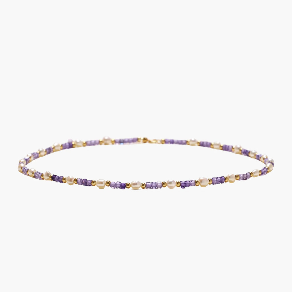 Delicate 18K gold vermeil necklace with alternating lavender zirconia beads and white freshwater pearls on cream background