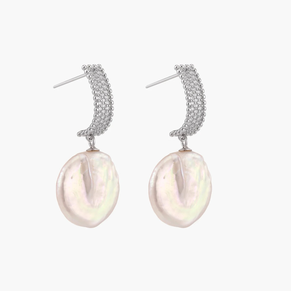 Rhodium-plated silver curved stud with pave stones and baroque pearl drop on white background